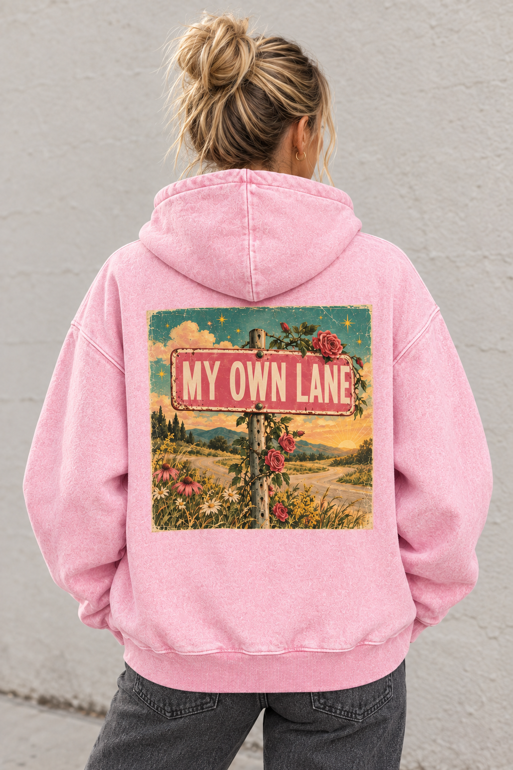 AI-generated mockup of a woman wearing the pink My Own Lane oversized hoodie, showing the floral roadside back graphic.