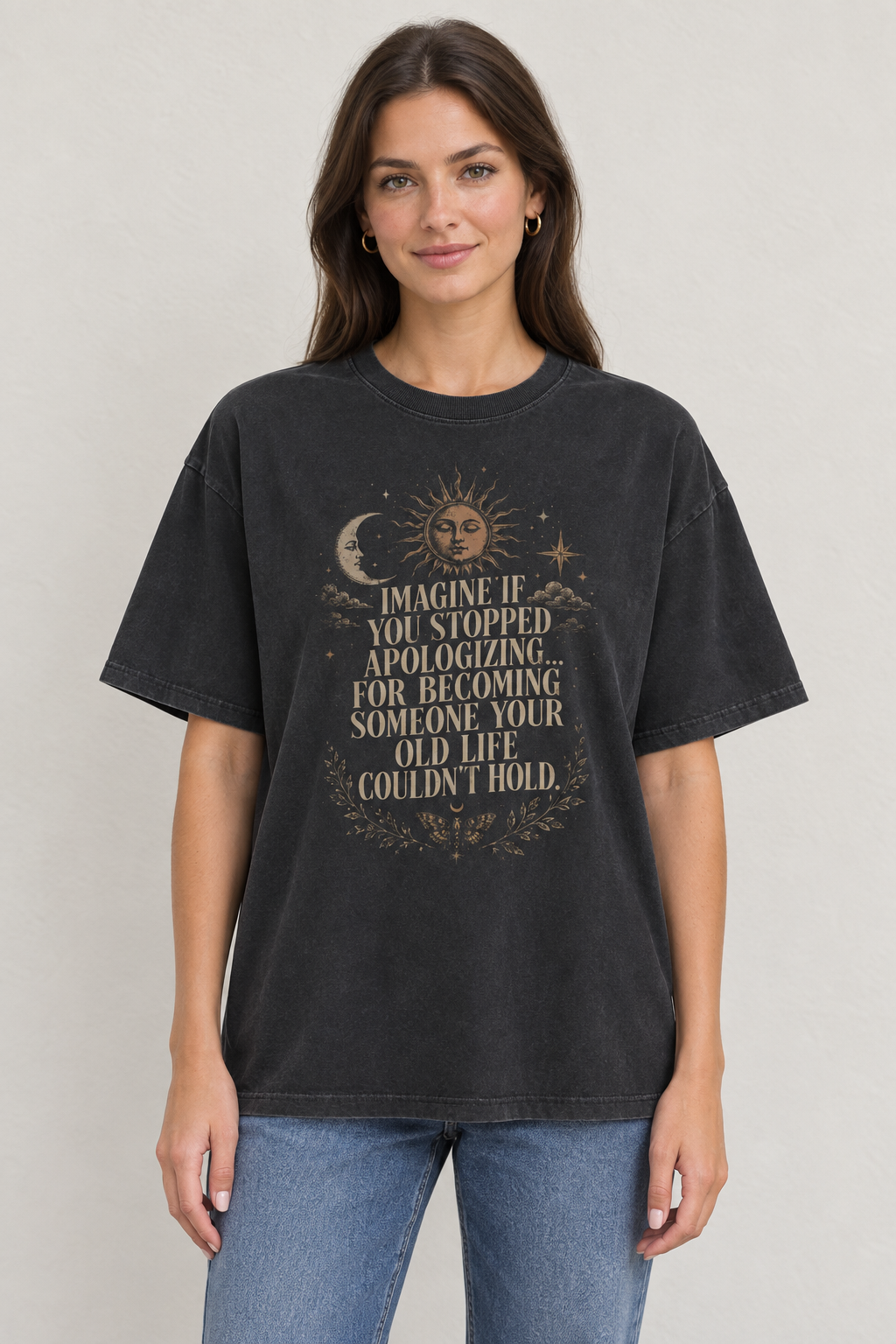 AI-generated mockup of a woman wearing a vintage-washed black No More Apologies celestial quote T-shirt with sun and crescent moon artwork.