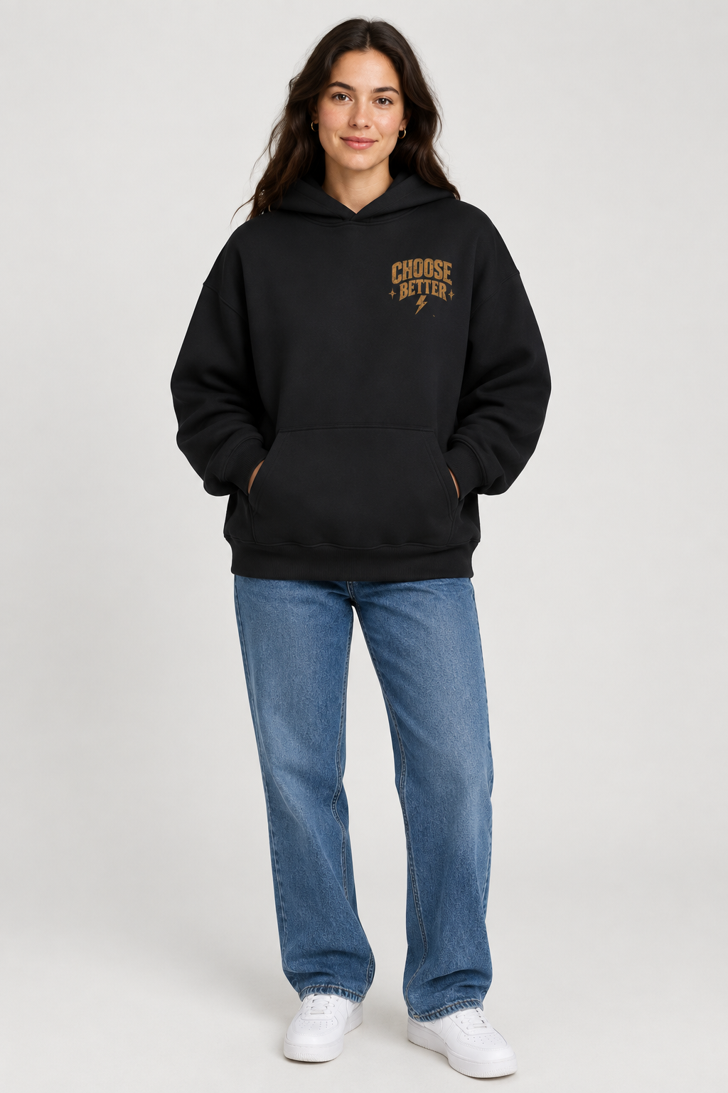 Woman wearing a black oversized hoodie with small gold Choose Better lettering and a lightning bolt on the left chest.