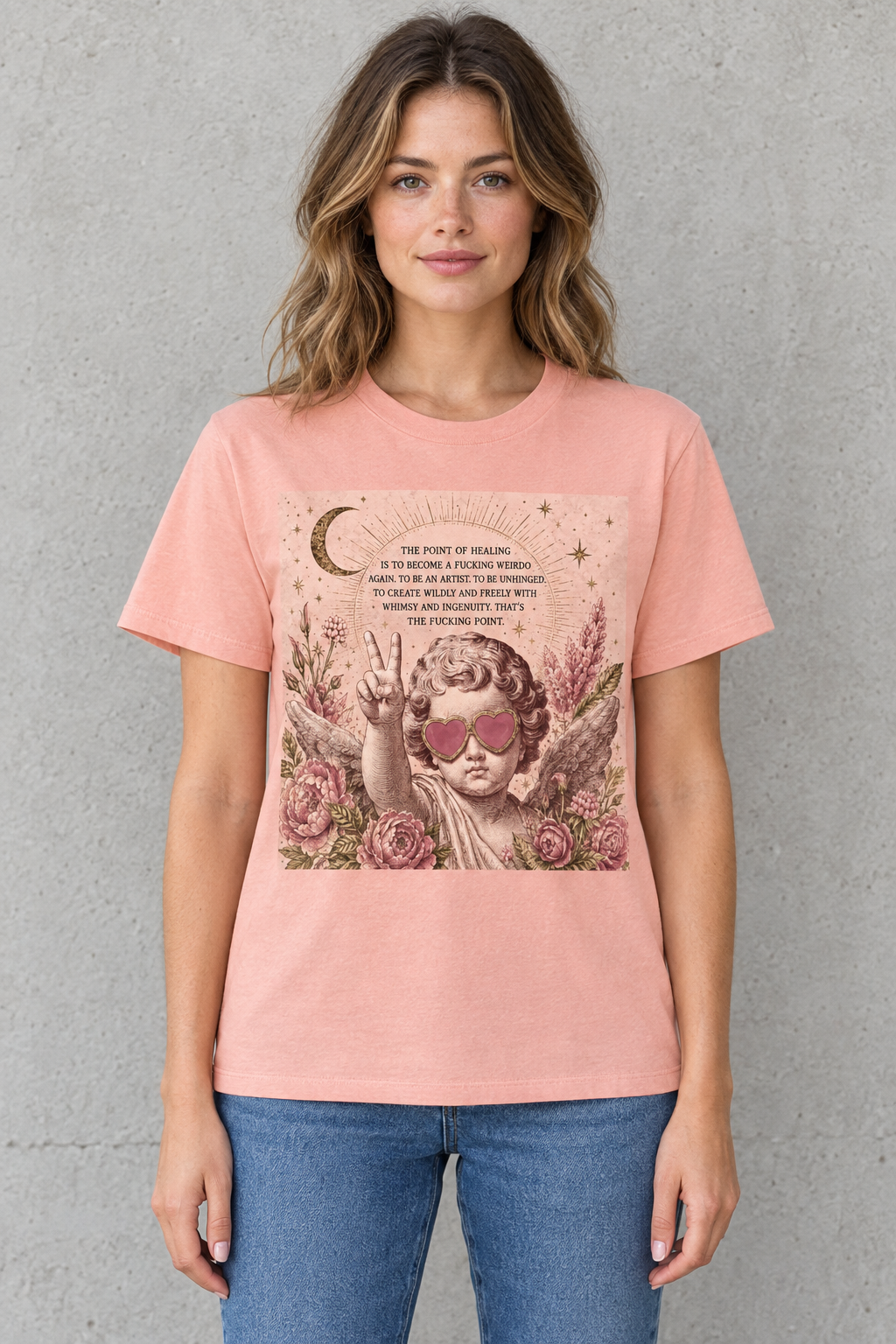 AI-generated mockup of a woman wearing the peach-pink Point of Healing cherub graphic cotton tee.